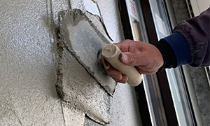 左官工事の外壁モルタル塗作業