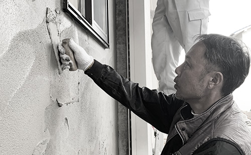 技術の高い左官職人が、鏝で壁を颯爽と塗っている。とても難しく、鍛錬を重ねる必要がある作業である。