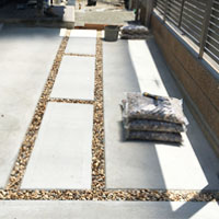 外構工事、玄関アプローチのカーポート下の施工です。コンクリートと玉砂利で、デザイン性の高い仕上がりになりました。