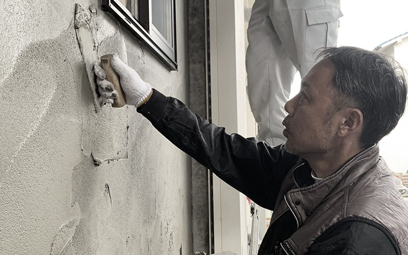 左官業務の外壁モルタル塗り作業です。鏝で塗りつけの作業をしています。